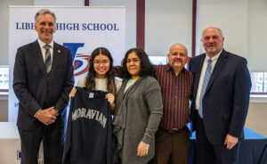 Liberty High School senior Milena Garay (holding Moravian sweatshirt) is one of two Bethlehem Area School District students to earn a full-tuition scholarship to Moravian University. She is pictured at the scholarship acceptance event with, to her right, Moravian University President Bryon L. Grigsby, and to her left her mom, dad, and School District Superintendent Dr. Jack P. Silva.